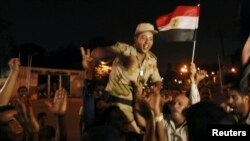 A soldier cheers with protesters opposed to Egyptian President Muhammad Morsi as they celebrate in front of the Republican Guard headquarters in Cairo after Morsi was deposed late on July 3. 