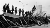 People stand on a barricade in front of the Russian White House in Moscow, August 21, 1991.