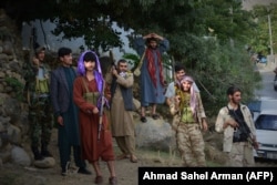 Armed men who have recently joined the fight against the Taliban stand along a road in Bazarak, Panjshir Province, on August 18.