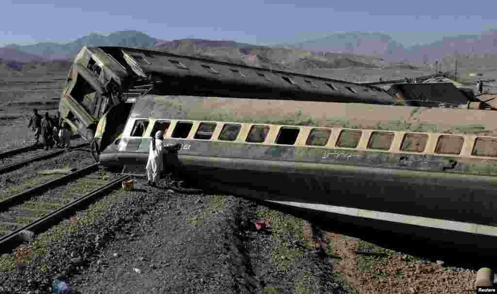 A passenger looks for his belongings after a train derailed in Quetta, Pakistan. (Reuters/Naseer Ahmed)