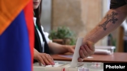 Armenia - A voter casts a ballot at a polling station in Yerevan, June 7, 2026.