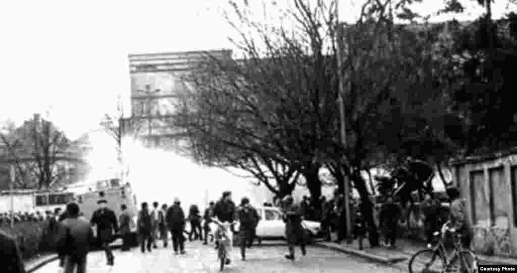 Timișoara, 16 decembrie 1989. Protestatarii sunt împrăștiați de scutieri și de forțele de ordine care folosesc tunuri cu apă. Aceștia ripostează și reușesc să arunce unul dintre furtunuri în râul Bega. Sunt însă operate numeroase arestări.&nbsp;&nbsp;