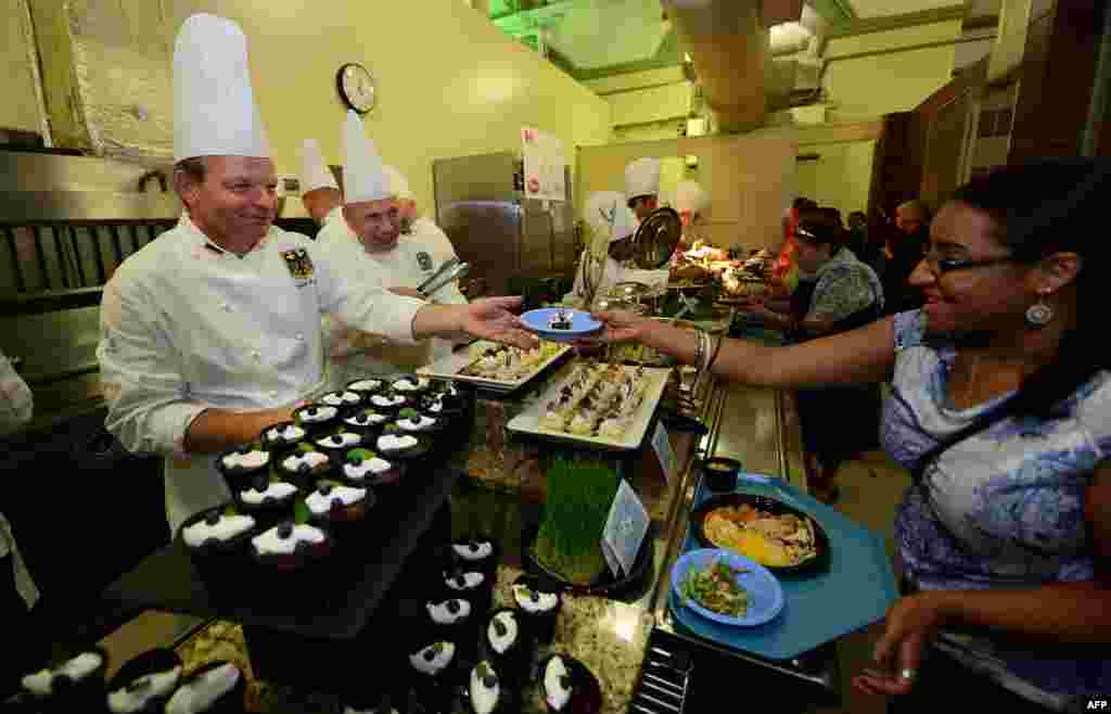 Chefs of world leaders serve dishes they prepared to New York residents in need at the Xavier Mission food pantry in New York. At left is Ulrich Kerz, chef to German Chancellor Angela Merkel. (AFP/Emmanuel Dunand)