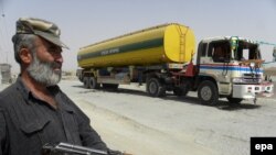 Standing guard near an oil tanker that was allegedly attacked by Taliban militants near the Afghan border in Chaman in July