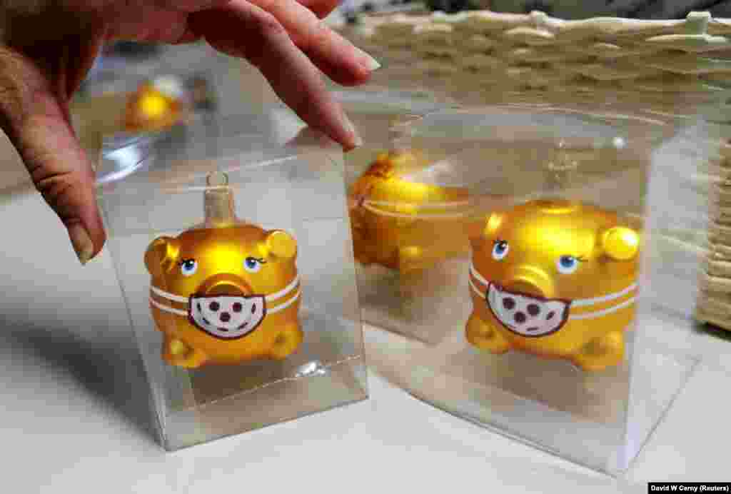 A worker packs glass Christmas tree decorations shaped like pigs with face masks at OzdobaCZ factory, as the spread of the coronavirus disease (COVID-19) continues in Dvur Kralove nad Labem, Czech Republic, December 1, 2020.