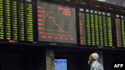 A Pakistani stockbroker watches share prices on a digital board during a trading session at the Pakistan Stock Exchange in Karachi (file photo)