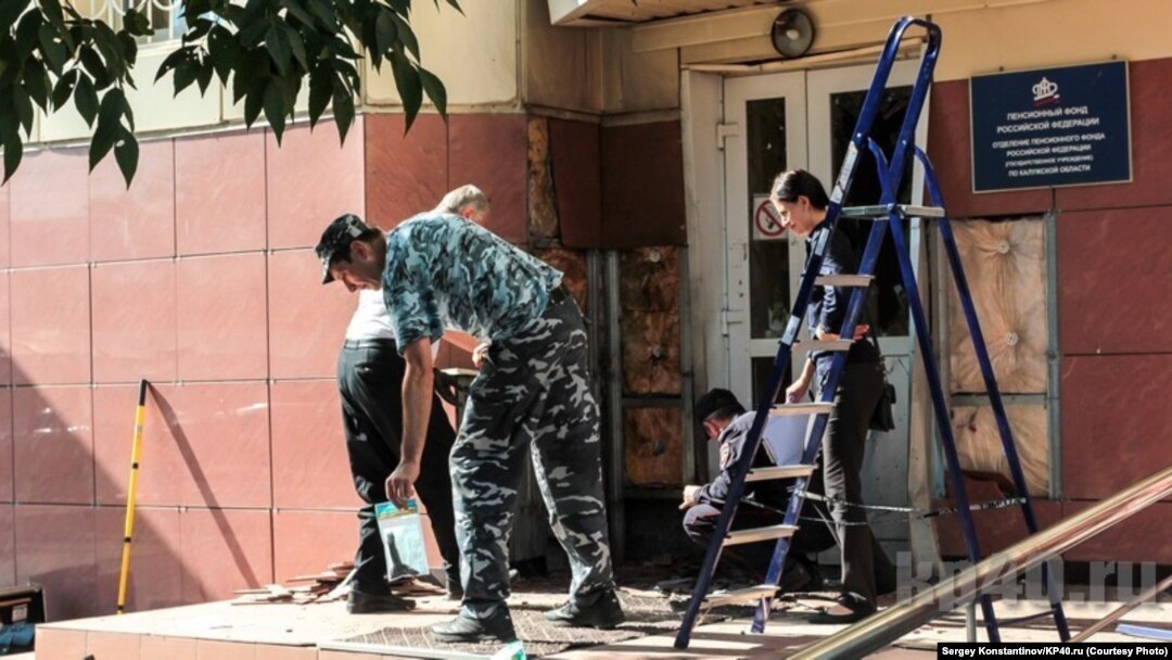 Workers repair damage at the site of a blast outside the national Pension Fund office in Kaluga on August 3. 