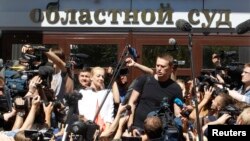 Алексей Навальний ва турмуш ўртоғи Киров област суди биноси олдида журналистлар билан суҳбатлашмоқда.