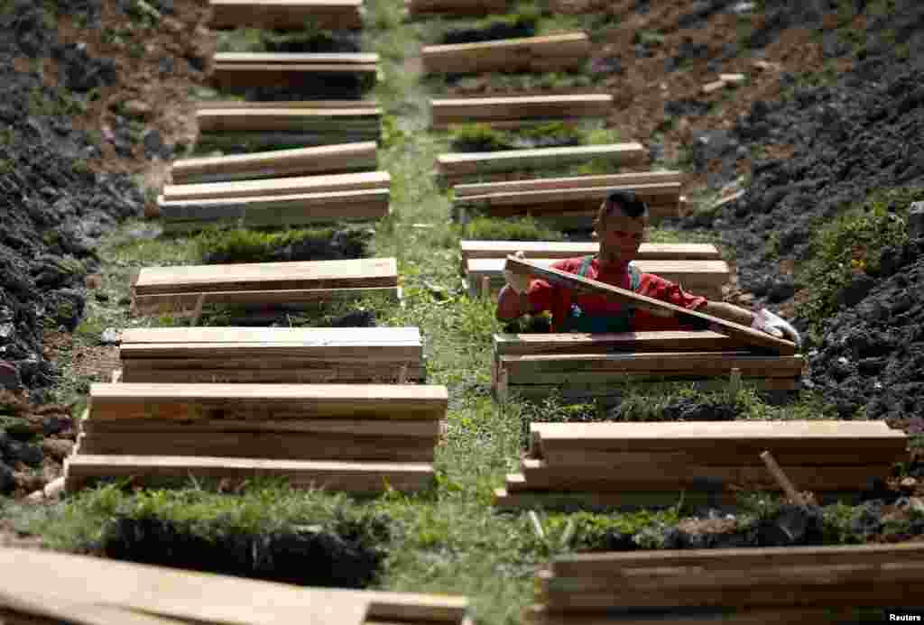 A worker prepares graves ahead of a ceremony at a memorial center for the victims of the Srebrenica massacre in Potocari, Bosnia-Herzegovina, on July 7. (Reuters/Dado Ruvic)