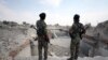 Syrian rebel fighters stand near the destroyed Uwais al-Qarni shrine in Raqqa, Syria, on September 16.