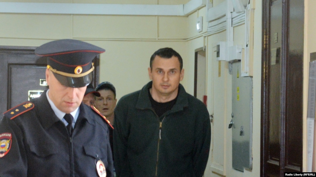 Олега Сенцова ведут в зал суда. 8 апреля 2015 года