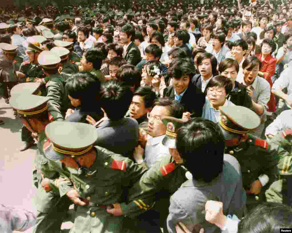 Crowds of jubilant students surge through a police cordon before pouring into Tiananmen Square on June 4, 1989.