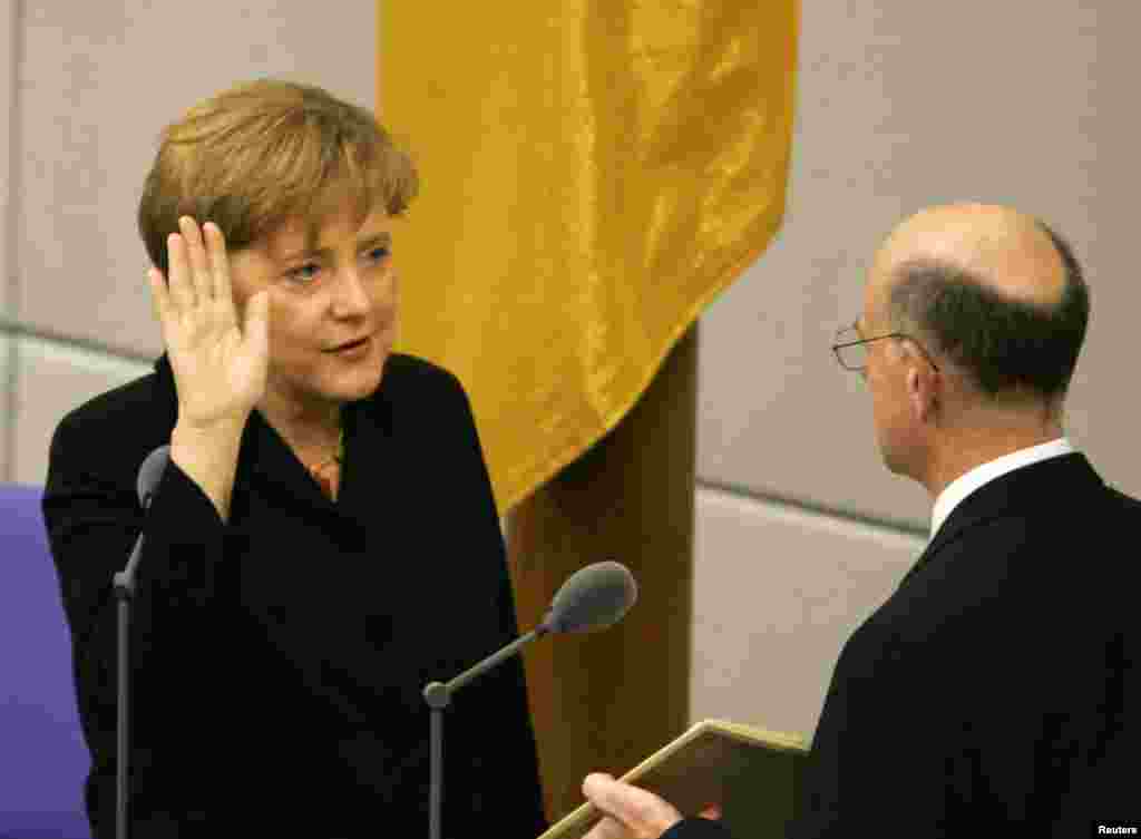 Лідер Християнсько-демократичної партії Німеччини Анґела&nbsp;Меркель складає присягу канцлера в парламенті у Берліні, 22 листопада 2005 року. У віці 51-го року, вона стала першою жінкою-канцлером Німеччини, та першим канцлером, який виріс у екс-комуністичній східній Німеччині (Німецька Демократична Республіка)