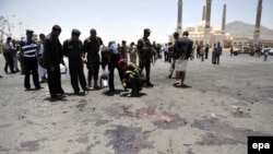 Police inspect the site of a suicide bombing targeting a military parade in Sanaa on May 21.