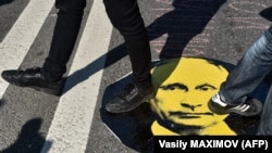 Protesters step on a sticker with an image of Russian President Vladimir Putin during a rally against the government's proposed reform hiking the pension age in Moscow in July.