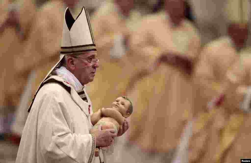 Pope Francis holds a statue of the the baby Jesus at the end of a Christmas Eve mass in Saint Peter&#39;s Basilica in the Vatican on December 24. (Reuters/Tony Gentile)