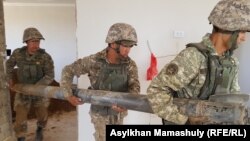 Оқ-дәрі қоймасындағы жарылыс кезінде үйге түскен снарядты қазып алып, әкетіп бара жатқан саперлар. Түркістан облысы, 29 маусым 2019 жыл.