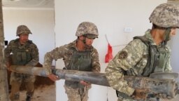 Саперы убирают из дома в городе Арысь фрагменты боеприпасов, Туркестанская область. 29 июня 2019 года
