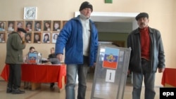 Local election commission members carry a ballot box at a polling station in Luhansk on October 30, ahead of the separatist-organized voting on November 2.