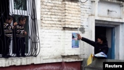 Tajik children watch a supporter of the Islamic Renaissance Party paste a campaign poster on a wall in the capital, Dushanbe, in February 2015. Within a few months it would be disbanded.