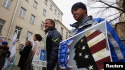 Activists hold placards outside Golos's offices during a protest against the organization in Moscow on April 5.