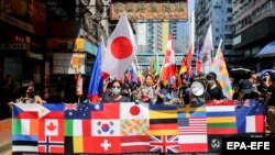 CHINA - Anti-government activists hold a banner with various country flags during protests on China's National Day in Hong Kong, China, 01 October 2019
