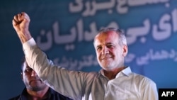 Irania - Masoud Pezeshkian raises his fist as he arrives for his campaign rally at a stadium in Tehran on July 3, 2024