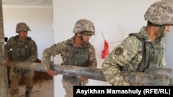 Military workers clear debris in the aftermath of the explosion in Arys, a small town in the Turkestan region, in June 2019.