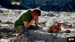A handout photograph taken and released by the Dnipropetrovsk Regional Military Administration shows a man at the site of a house destroyed in a Russian strike on the Ukrainian village of Radushne.