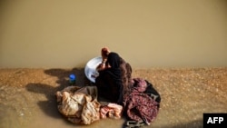 یک زن افغان در حال شستن لباس (تصویر آرشیف)