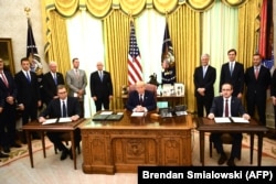 Президент Сербии Александр Вучич (слева) и премьер-министр Косова Авдулла Хоти (справа) на церемонии подписания экономического соглашения в Вашингтоне в присутствии президента США Дональда Трампа (в центре).