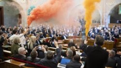 A Momentum képviselői a szavazás előtt tiltakozásul piros-fehér-zöld füsttel borították be az üléstermet 2025. március 18-án