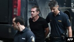 Rus Alekandr Vinnik u pratnji policajaca dolazi u zgradu suda u Grčkoj 2017. godine