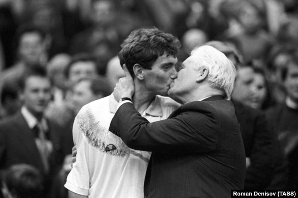 Image of an older man kissing a young athlete
