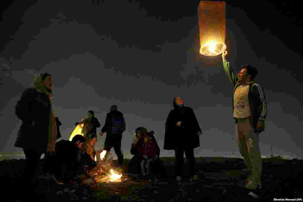 An Iranian man releases a lit lantern during a celebration, known as &quot;Chaharshanbe Souri,&quot; or Wednesday Feast, marking the eve of the last Wednesday of the solar Persian year, Tuesday, March 19, 2019 in Tehran, Iran.