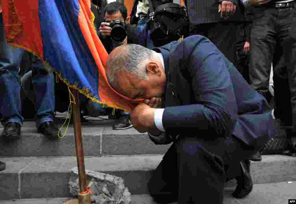 Raffi Hovannisian kisses an Armenian flag during the opposition rally.