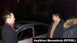 Жанболат Мамай (второй справа) рядом со своим автомобилем. В тот вечер Мамай сообщил, что неизвестные разбили окно и зеркало его машины. Алматы, 6 декабря 2016 года.