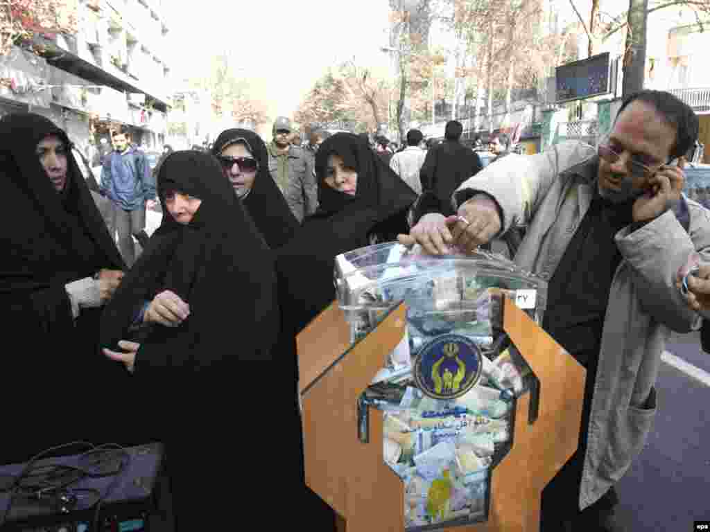 ....ва дар Теҳрон - Caption: epa01586825 Iranian demonstrators donate financial aid, during an anti-Israeli rally in Tehran, Iran, 29 December 2008. Tens of thousands took part in the state-organised demonstration in the capital Tehran to protest against the Israeli raids on Gaza strip, shouting 'death to Israel and death to America', as they burned Israeli flags