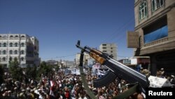 A defected army soldier now backing Yemen's antigovernment protesters waves his AK-47 rifle during a protest march in Sanaa on October 20.