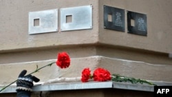 A woman places a flower next to plaques commemorating victims of Soviet repression in central Moscow. Incidents of vandalism against the memorials are now on the rise. 