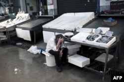 A man working at the central fish market waits for customers in Athens late last month.