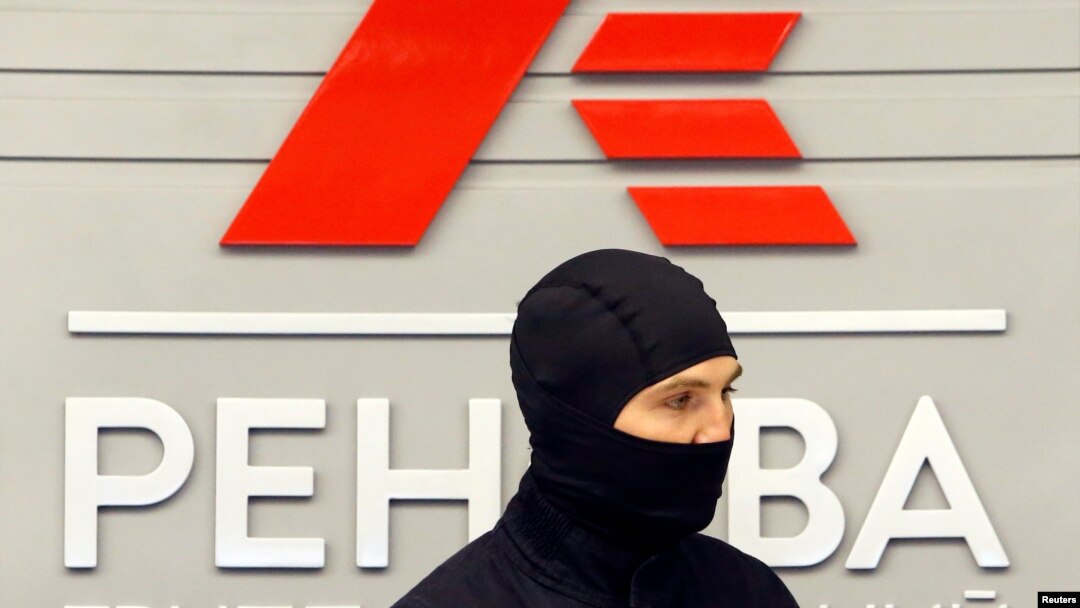 Сотрудник ФСБ на фоне лого компании "Ренова"