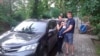 Инна Хэльмут, Олег Погребняк и их сын около автомобиля, из которого их силой вытаскивали полицейские