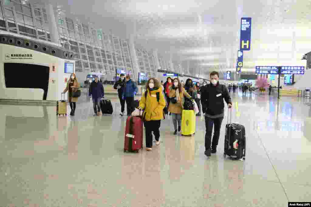 CHINA -- People wear face masks as they walk through the terminal at Wuhan Tianhe International Airport as they prepare to board an evacuation flight for EU nationals in Wuhan in central China's Hubei Province, February 1, 2020