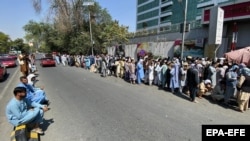 صف‌های طولانی شماری از افغان‌ها که برای گرفتن پول‌شان در مقابل بانک‌ها صف کشیده اند.