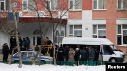 Полицейские у здания средней школы в Москве, где произошла стрельба. 3 февраля 2014 года.