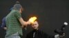 A volunteer takes a picture of himself receiving a haircut as a hairstylist uses fire to &quot;cut&quot; the hair during a &quot;Barber Trash&quot; show on the first day of the annual Ideal of Beauty spring festival in the Siberian city of Krasnoyarsk, Russia (Reuters/Ilya Naymushin)