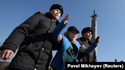 Сотрудники полиции задерживают протестующую во время митинга, организованного сторонниками оппозиции после гибели активиста в полицейском изоляторе. Казахстан, 1 марта 2020 года.
