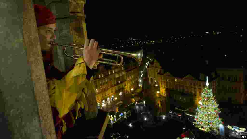 A trumpeter plays from the Old Town tower above the traditional Christmas market in Old Town Square in central Prague. (AFP/Michal Cizek)