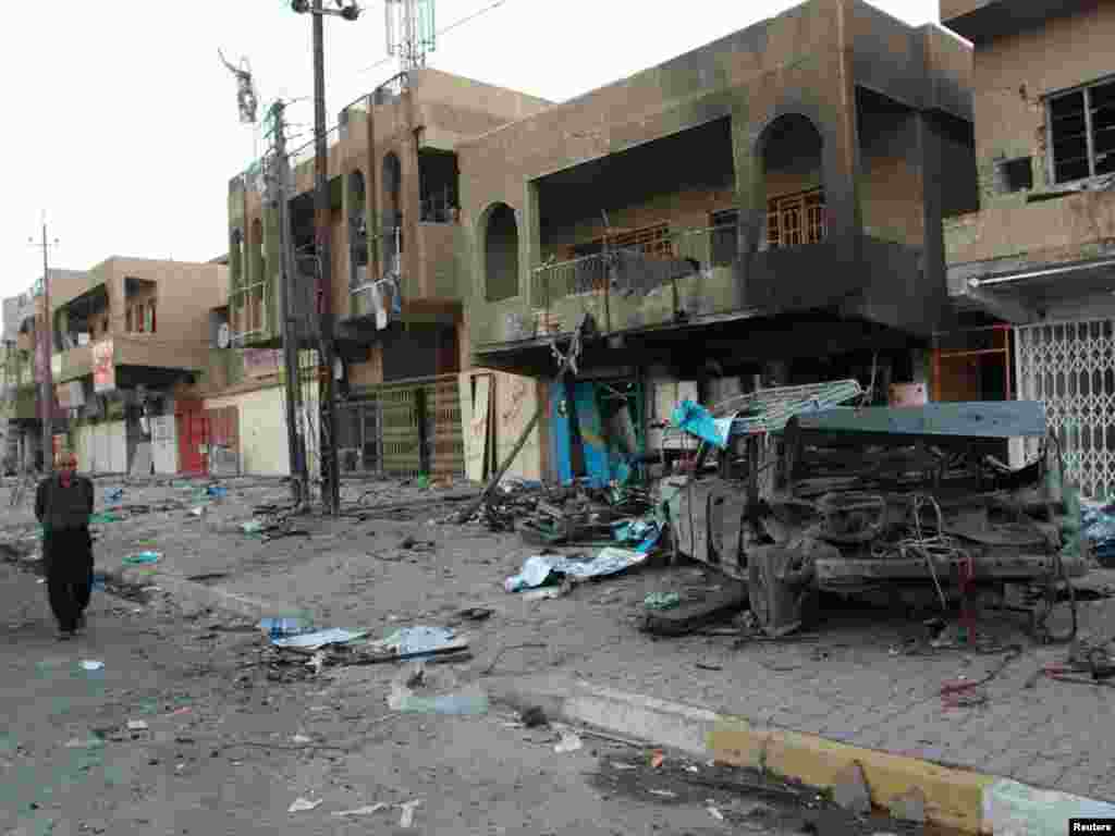 ناحیه جهاد در بغداد- ۱۲ آبان - A resident walks at the site of a bomb attack in Baghdad's Jihad district November 3, 2010. A series of bombs rocked mainly Shi'ite areas of Baghdad on Tuesday, killing at least 40 people and wounding dozens two days after al Qaeda militants staged a bloodbath when they took hostages in a Christian church. REUTERS/Ahmed Malik (IRAQ - Tags: CIVIL UNREST)